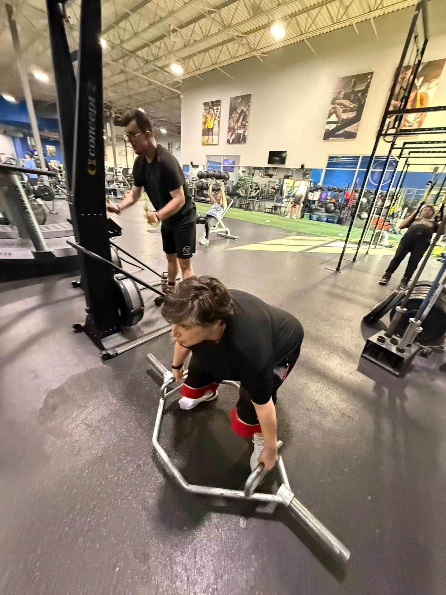 Athletes lifting a trap bar and rowing during a session