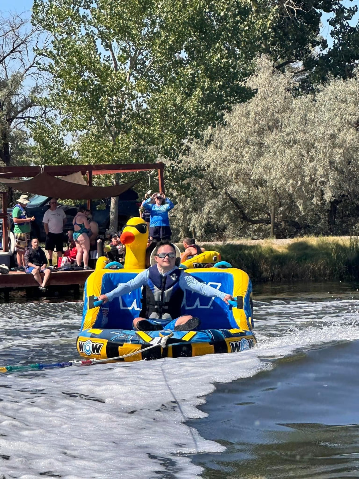An athlete riding a tube behind a boat on the river