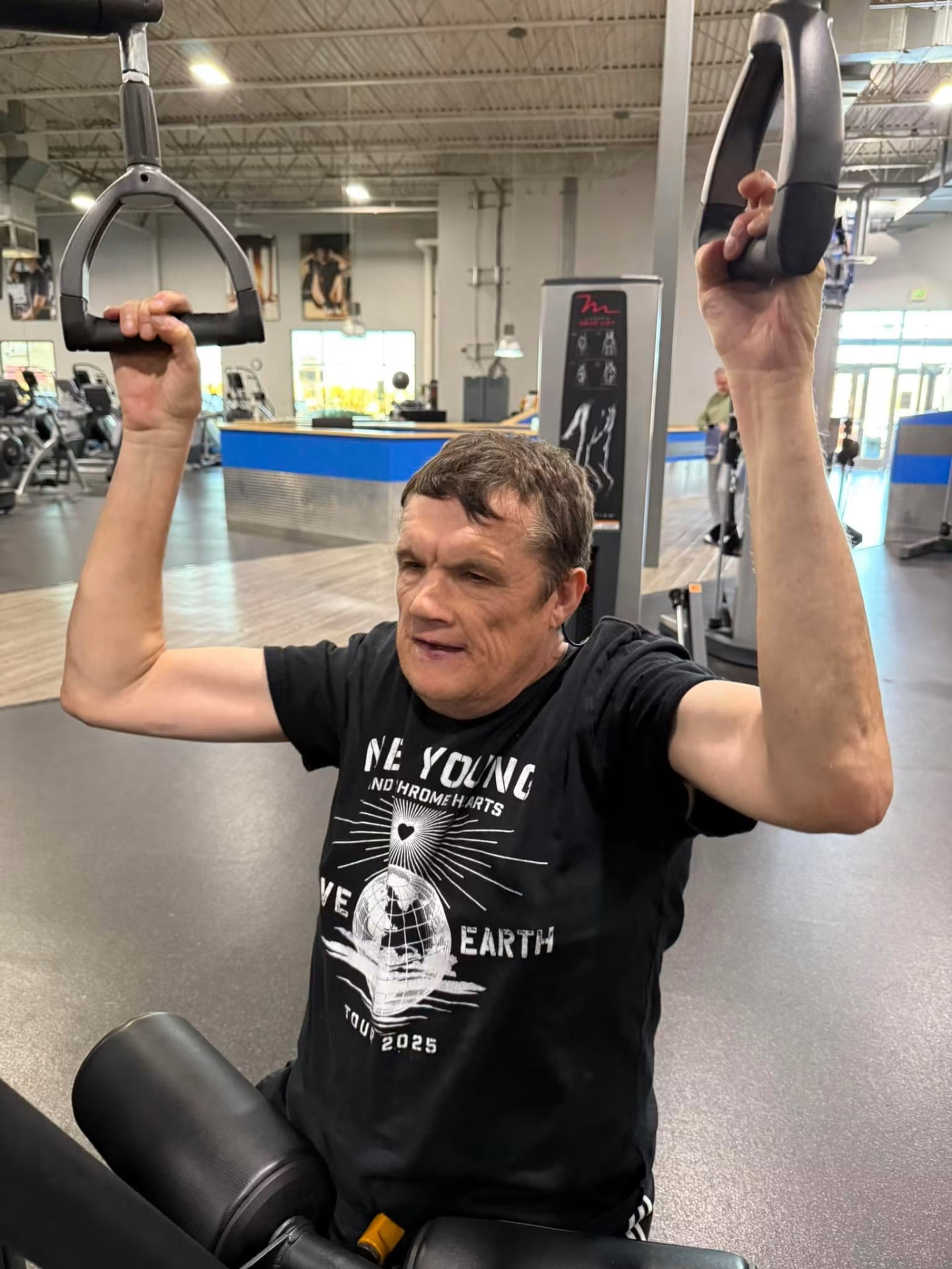 Athlete pressing overhead on a shoulder press machine