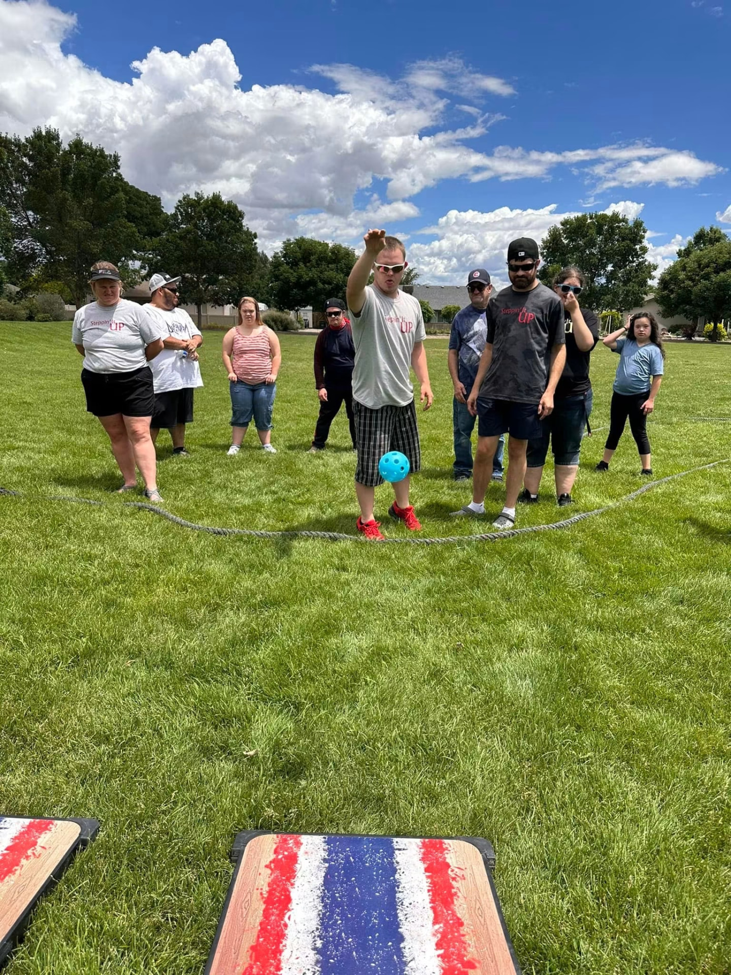 An athlete tossing a ball during a lawn game in the park