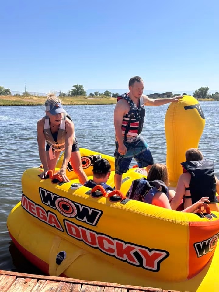 Athletes climbing onto a big yellow tube at the dock