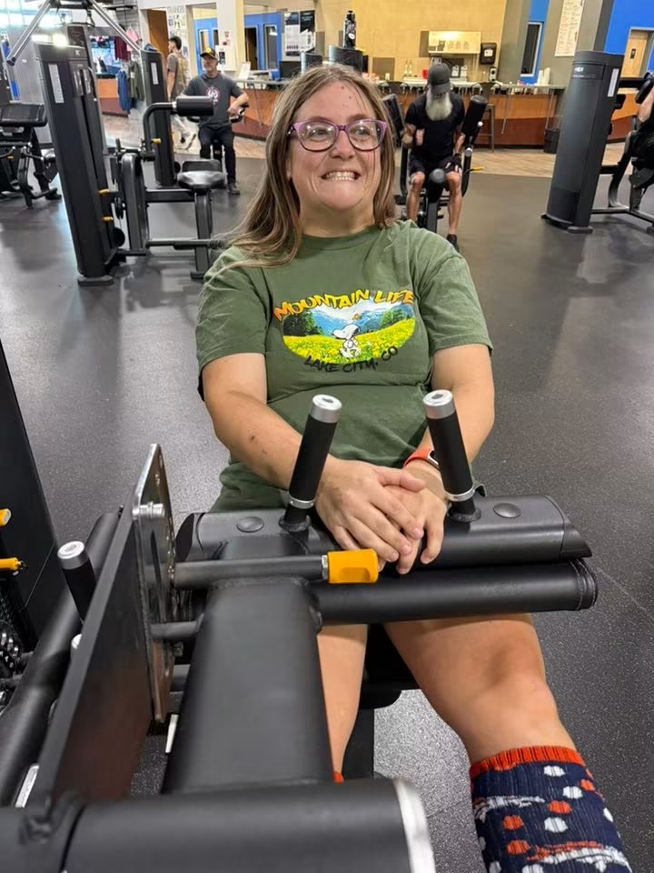 Smiling athlete using a leg extension machine